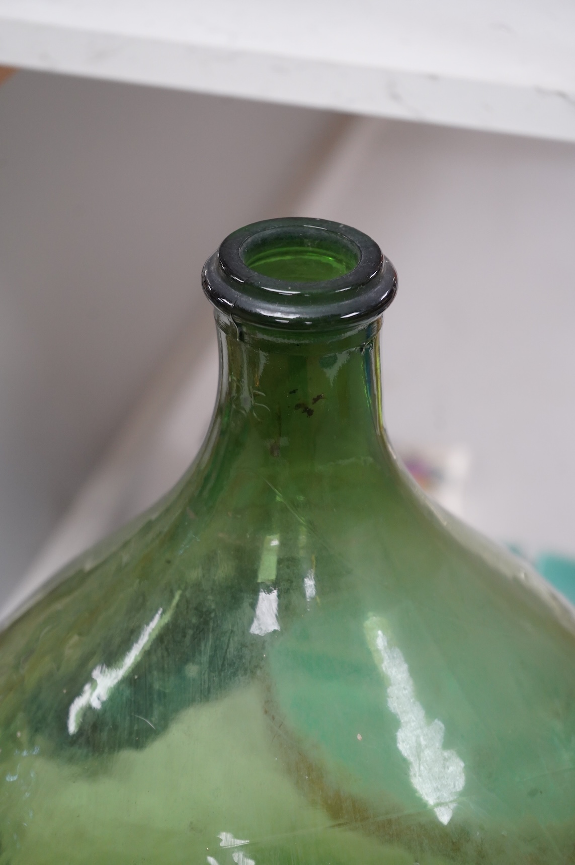 A large green glass carboy 51cm high